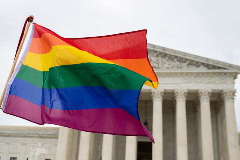 FILE - Supporters of the LGBT wave their flag in front of the U.S. Supreme Court, Oct. 8, 2019, in Washington. (AP Photo/Manuel Balce Ceneta, File)
