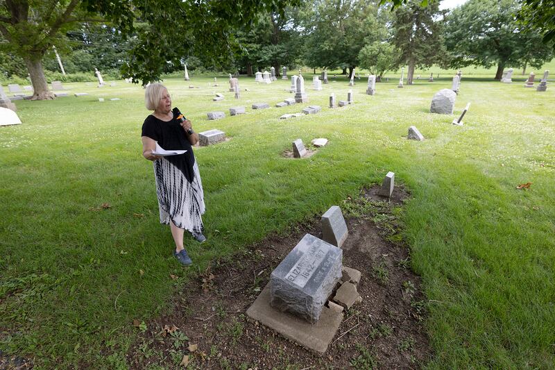 Polo Historical Society member Beth Wiegmann talks near the grave of Elizabeth Hamlin on Saturday, June 28, 2025. Hamlin was a former slave who was brought to Polo by Maria Waterbury to care for her mother.