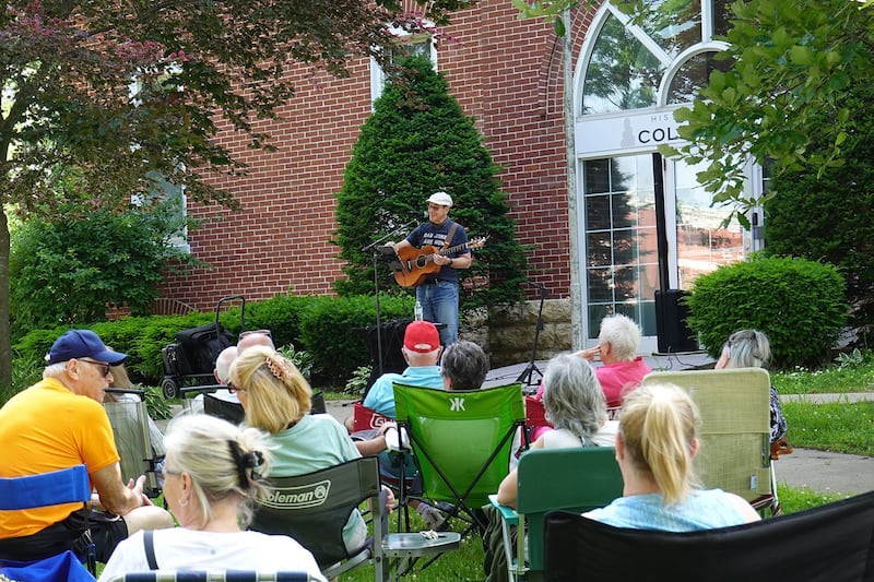 Dennis Svehla, performing as Denny Diamond, plays on the Mt. Morris Campus in front of College Hall during PorchFest on Saturday, June 14, 2025. College Hall is home to the Mt. Morris Historical Museum and the Encore Art Gallery.