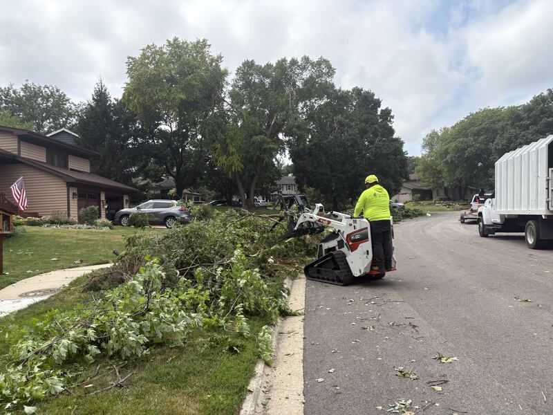 A worker cleans up storm damage in Cary Aug. 17, 2025.