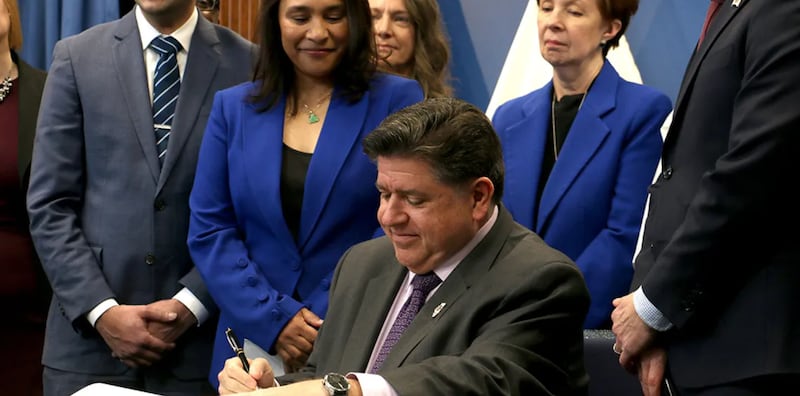 Gov. JB Pritzker signs House Bill 767 at a Dec. 2 news conference in Chicago.