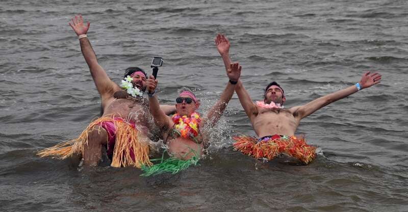 Jason Steinlauf of Cary (from left), Alex Brenke of Elk Grove Village and Brian Kleinman of Wauconda brave the wind and the cold water Sunday, March 22, 2026, for the Fox Lake Polar Plunge. The event is a fundraiser for Special Olympics.