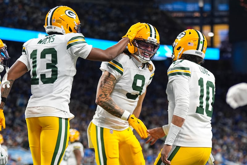 Green Bay Packers wide receiver Christian Watson (9) celebrates a touchdown with wide receiver Dontayvion Wicks (13) and quarterback Jordan Love (10) against the Detroit Lions during the second half an NFL football game in Detroit, Thursday, Nov. 27, 2025. (AP Photo/Ryan Sun)