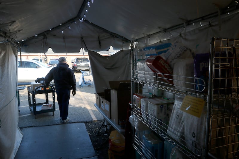 Volunteer Tom Zorn waits in the tent attached to the FISH of McHenry Food Pantry, 3515 N. Richmond Road in Johnsburg, with a cart of food to give to a recipient on Tuesday, Jan. 10, 2023. The pantry, which has changed how it distributes food since the COVID-19 pandemic, is now raising $150,000 to add more storage and a heated garage onto the building.