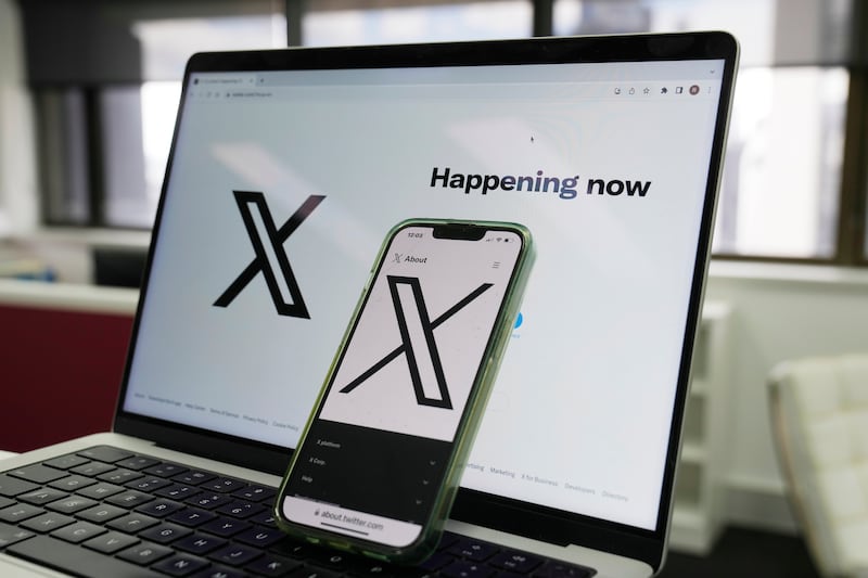 FILE - The opening page of X is displayed on a computer and phone, Oct. 16, 2023, in Sydney. (AP Photo/Rick Rycroft, File)