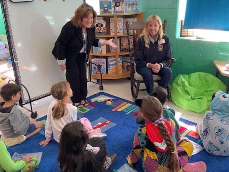 State Sen. Sue Rezin and Principal  Laurel Mateyka share a story with students at P.H. Miller Elementary School in Plano on Oct. 9.