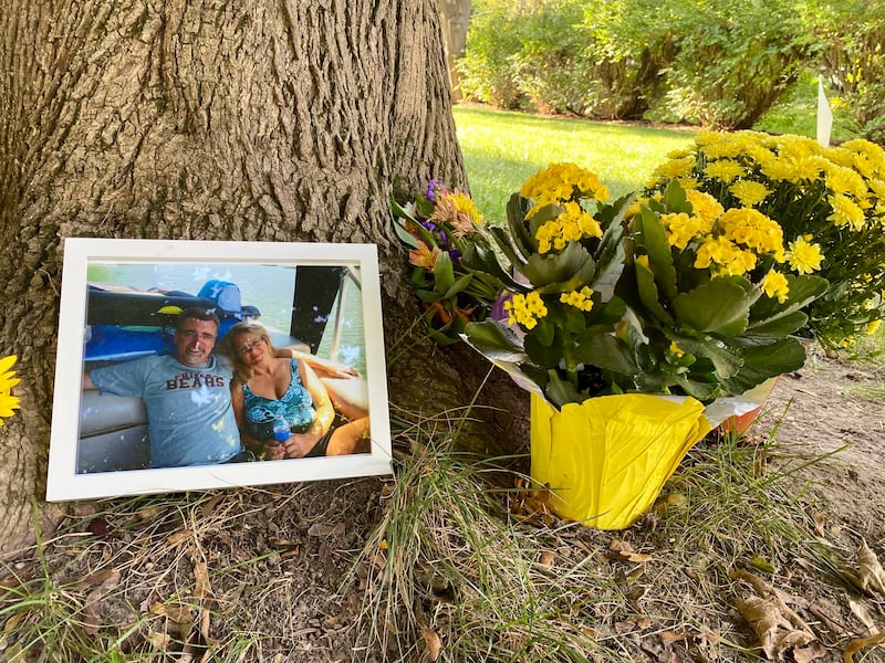 Memorial flowers, a photo and messages of love were placed outside the home of Gary Schmidt and Holly Schmidt on Friday, Oct. 3, 2025, on Oakland Drive in Sycamore. The Schmidts, shown in the photo, were found dead in their home on Tuesday, authorities said.