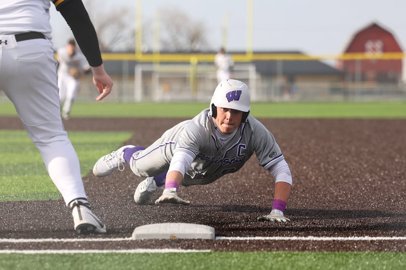Wilmington's Kyle Farrell dives safely back to first base during the Wildcats' 3-0 victory over Herscher on Monday, April 14, 2025.