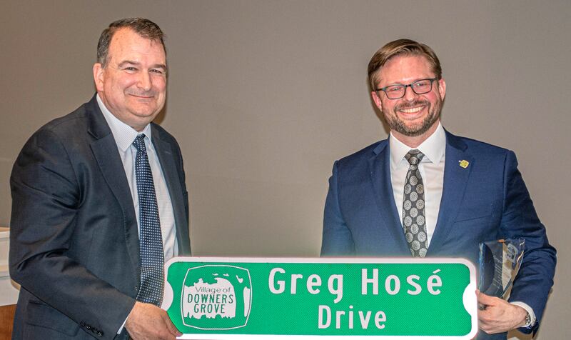 Downers Grove Mayor Robert Barnett presents a commemorative street sign to Commissioner Greg Hose at Tuesday's village council meeting. Hose is leaving the council after a 12-year tenure.