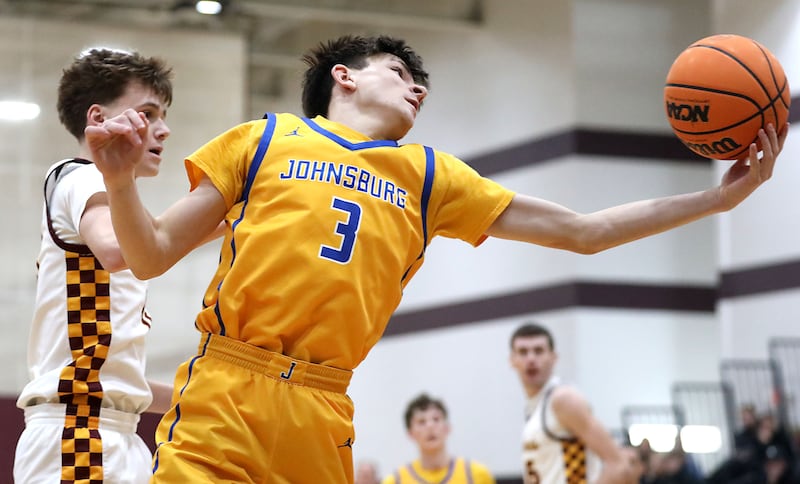 Johnsburg's Trey Toussaint (right) grabs a rebound in front of Richmond-Burton's Gavin Radmer during a Kishwaukee River Conference boys basketball game on Tuesday, Jan. 27, 2026, at Richmond-Burton High School.