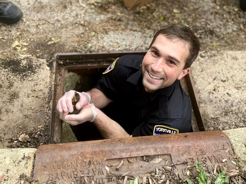 Fresh from his swearing-in with the Yorkville Police Department, Officer Sam Tickel helps rescue 11 ducklings from a storm drain. The officers were able to reunite the ducklings with their waiting mother.