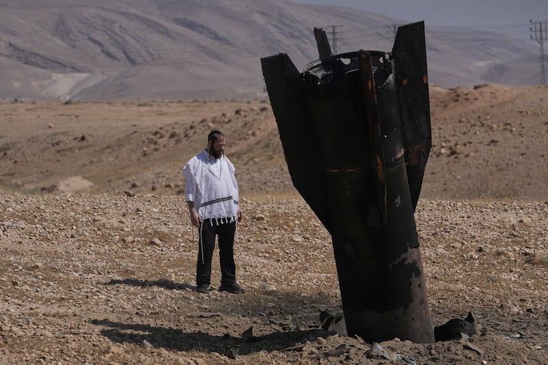 A man looks at the wreckage of an Iranian missile that landed near the West Bank city of Jericho Monday, June 8, 2026. (AP Photo/Mahmoud Illean)