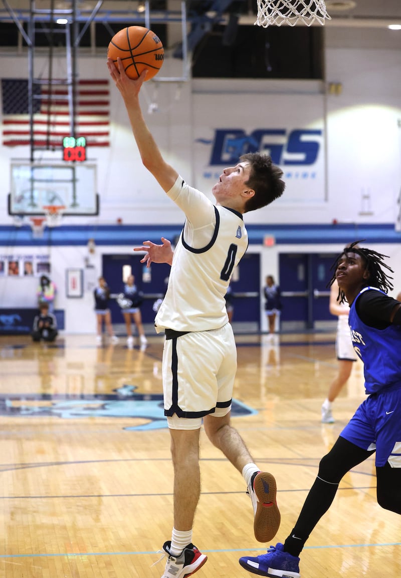 Downers Grove South's Sean Day shoots a reverse layup in front of Proviso East's Karl Glenwright during their game Friday, Feb. 14, 2025, at Downers Grove South High School.
