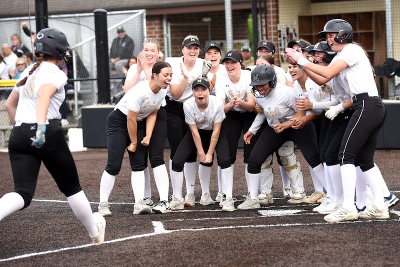 Members of the Bishop McNamara softball team greet Rhaya DePaolo, left, at home plate following her home run during the Class 2A Seneca Regional semifinals against Wilmington Tuesday, May 19, 2026.