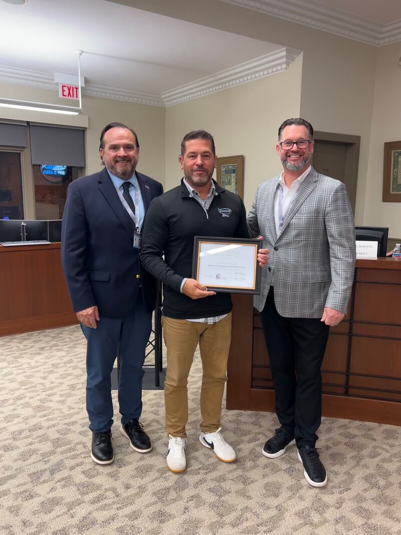 Owner Mario Spina (middle) of Parent Petroleum receives the "Spirit of St. Charles Award" from Fifth Ward aldermen Ed Bessner (left) and Steve Weber at the Nov. 3, 2025 St. Charles city council meeting.