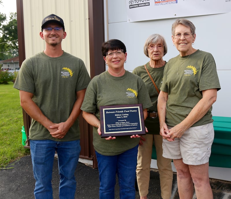Pantry volunteers Liam Cannon, Patty Crichton, Pat Heine and Alice Osterman pose with the ribbon cutting plaque on Aug. 5, 2025, in Sugar Grove
