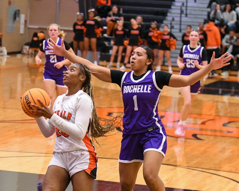 DeKalb's Zora Watts, left makes a basket while being defended by Rochelle's Carmela Bright during the game on Monday Dec. 2, 2024, held at DeKalb High School.