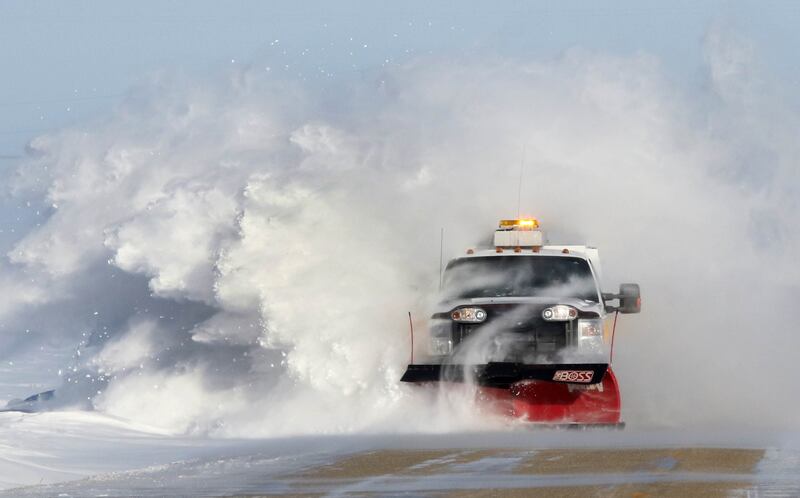A DeKalb County snowplow takes out some of the snow drifts on Somonauk Road near Hinckley Wednesday. Snow continues to blow across roadways in open areas causing poor visibility and drifts in the road.
