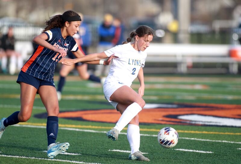 Lyons Township's Carolina Capizzi kicks the ball away from Naperville North's Kennedy Bertsch during a game on Wednesday, April 16, 2025 in Naperville.