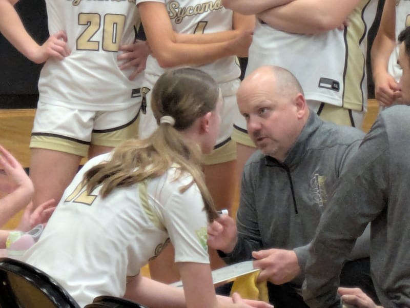 Sycamore coach Adam Wickness (right) talks to Sadie Lang (12) and the Spartans during a timeout during the team's Class 3A Sycamore Regional semifinal game against Freeport on Tuesday, February 17, 2026, a 58-57 win.