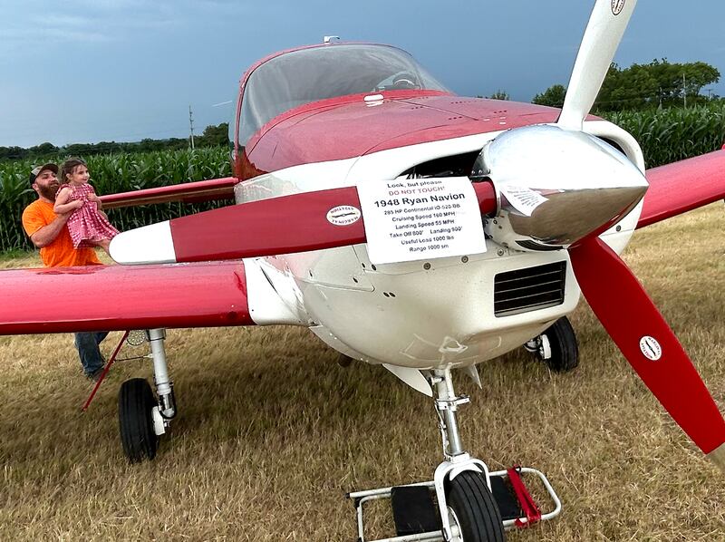 Harrison Miller, of Leaf River, lifts his daughter, Oakland, up to see inside of this 1948 Ryan Navion plane that was one of the planes on display at the Ogle County Airport's Fly in/Drive In Breakfast on Friday, July 4, 2025.