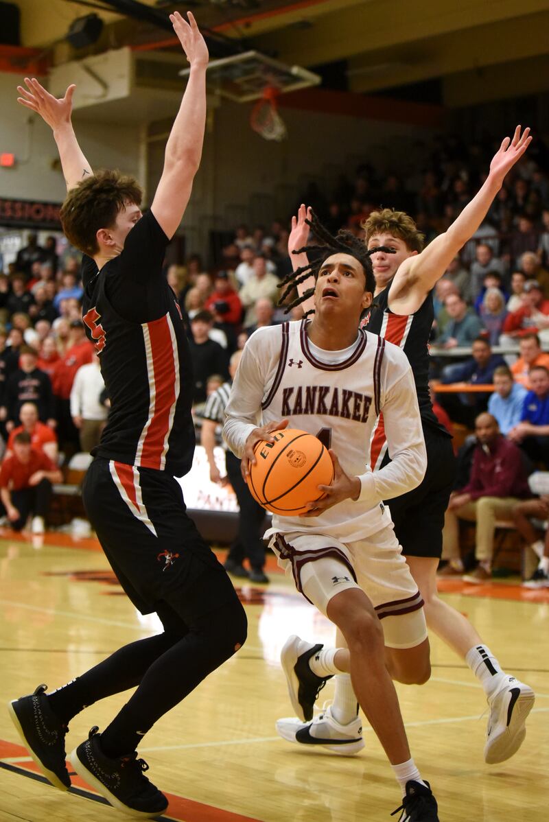Kankakee's Lincoln Williams looks to split through a pair of Metamora defenders during the IHSA Class 3A Washington Sectional semifinals Tuesday, March 4, 2025.