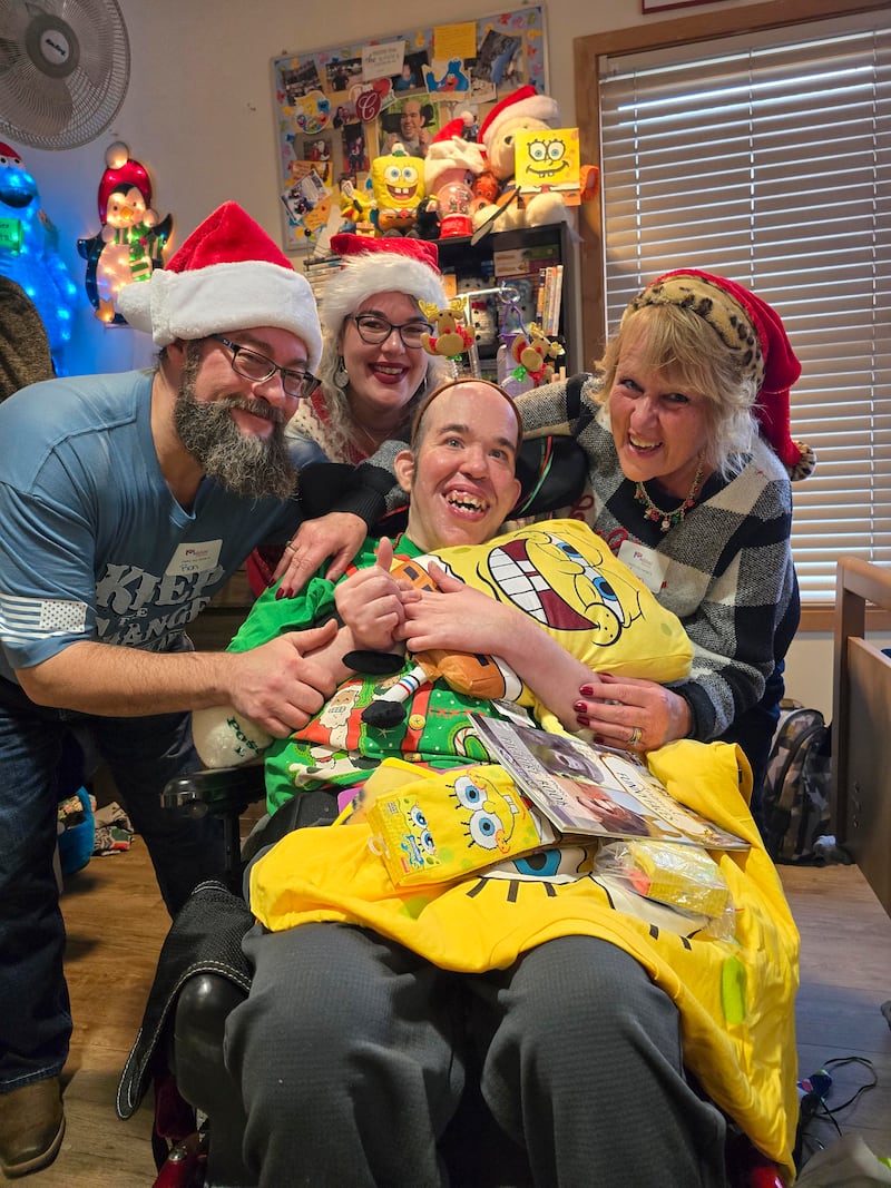 Marklund Hyde Center resident Chris Hicke is thrilled with his new Sponge Bob-themed gifts. His family assisted with opening his presents during Marklund’s annual Christmas gift opening event.