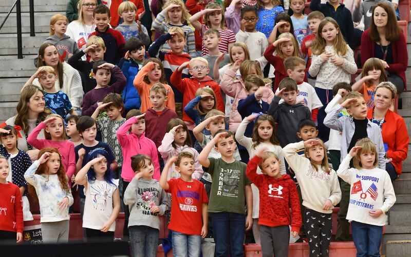 Oregon Elementary School students salute as they sing a song for all the branches of the the military during the Oregon School District's Veterans Day Assembly on Tuesday, Nov. 11, 2025. The event was held Tuesday morning in the Blackhawk Center and also included performances by junior high and high school band and choir students.
