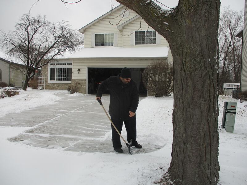 Michael Sepl shovels the driveway of his home on Blackwater Drive in the Wexford subdivision of Joliet on Wednesday. Feb. 12, 2025