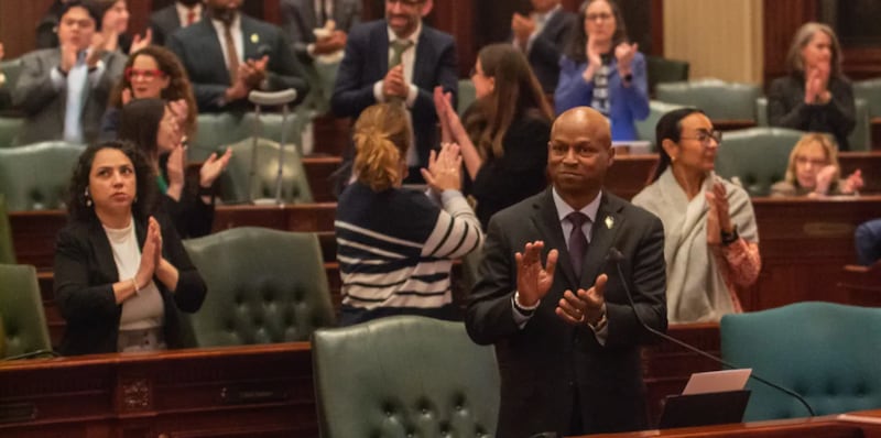 House Speaker Emanuel “Chris” Welce and members of the Democratic caucus applaud members of their staff early Sunday morning after the chamber approved the $55.2 million budget bill.