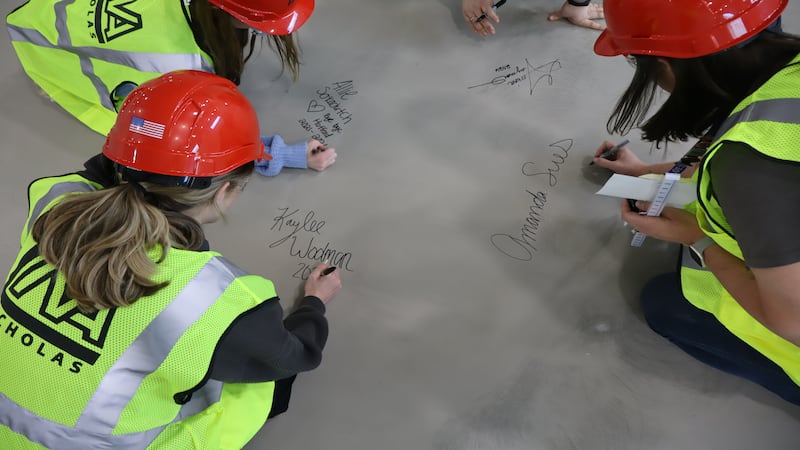 Staff and students in Joliet sign gym floor of new Hufford Junior High