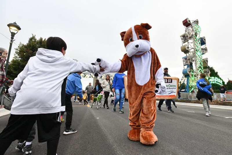 The South Creek Animal Hospital mascot high fives kids along the parade route during the Pet Parade at Manteno's Oktoberfest celebration in 2022. The Pet Parade returns at 6 p.m. Friday, Sept. 26, 2025.