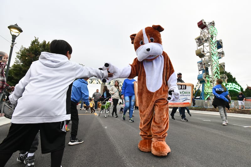 The South Creek Animal Hospital mascot high fives kids along the parade route during the Pet Parade at Manteno's Oktoberfest celebration in 2022. The Pet Parade returns at 6 p.m. Friday, Sept. 26, 2025.