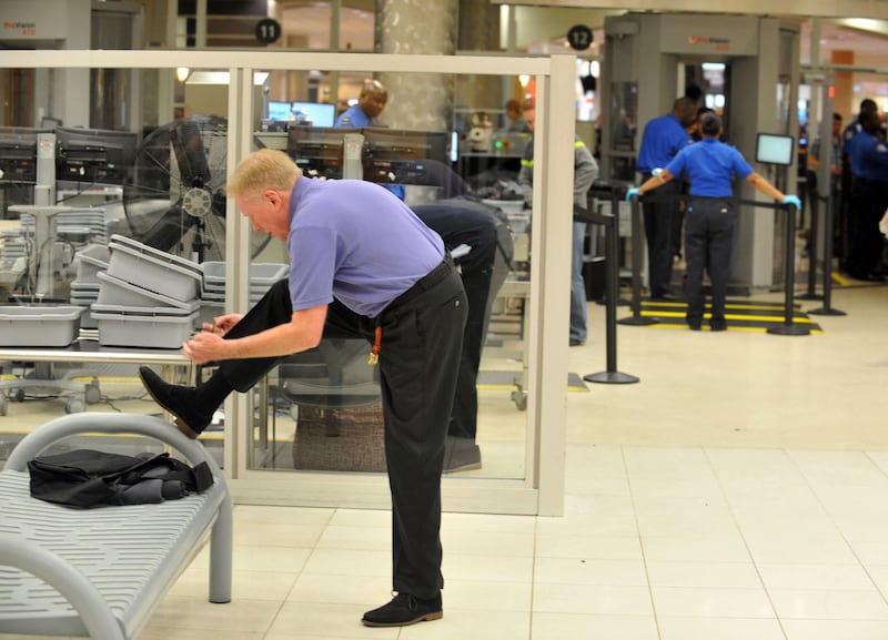 FILE - A traveler removes his shoes at Hartsfield-Jackson Atlanta International Airport on Wednesday, Jan. 15, 2014 in Atlanta. (Kent D. Johnson/Atlanta Journal-Constitution via AP, File)