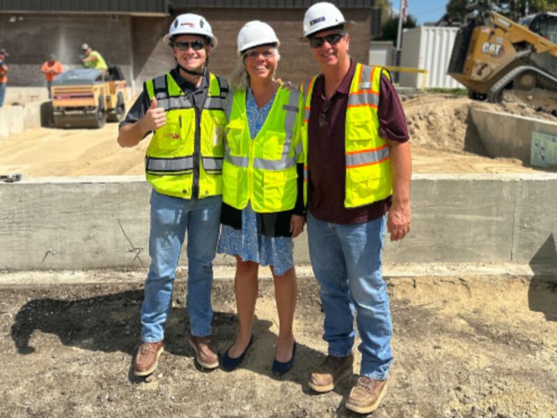 Library Director Resa Mai (center) with construction workers as they prepare the land for the library's new expansion.