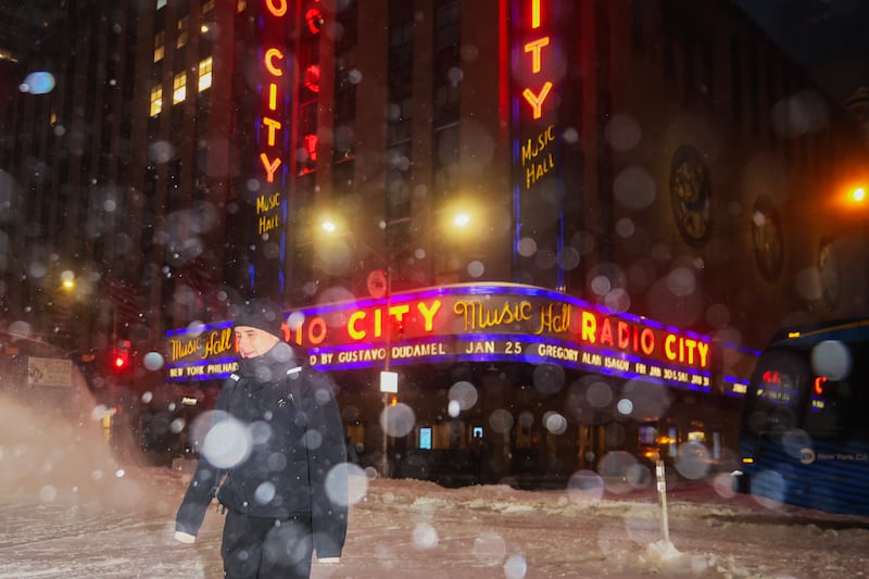 A pedestrian crosses the street near Radio City Music Hall during a winter storm, Sunday, Jan. 25, 2026, in New York. (AP Photo/Heather Khalifa)