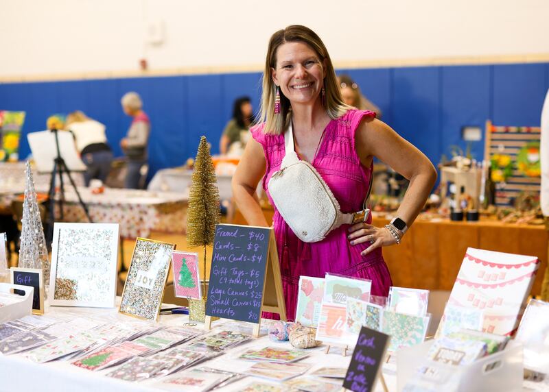 A crafter stands behind her booth at the Glen Ellyn Park District's craft fair