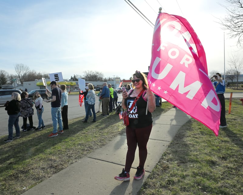 Emily Cahill, of Will County holds a “Women for Trump” sign as hundreds gathered on the curb on Ogden Ave. in Lisle in front of a Tesla dealership to demonstrate on Tuesday, March 18, 2025. She said she came to “protest the prostesters.”