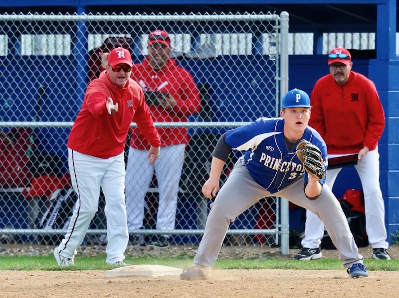 Hall coach Tom Keegan directs traffic to third base as Princeton's Luke Smith awaits the throw Monday at. Prather Field. The Red Devils won 10-4.