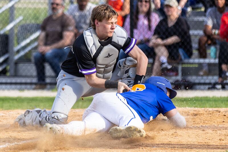 Downer’s Grove North catcher Jack Romsey tags out a Lyons Township runner at home during a game in Downers Grove on Monday, May 12, 2025.