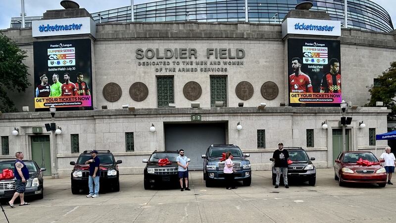 Veterans stand by their fully refurbished vehicles, donated by Midas' Project Spark initiative, at Soldier Field in Chicago on July 2, 2025.