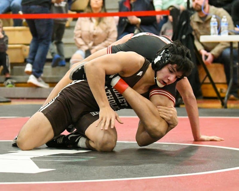 Aurelio Munzo of Joliet Catholic Academy keeps a hold of Vincent Konecki of Yorkville during the 132-weight class on Tuesday Feb. 25, 2025, held at Yorkville High School.