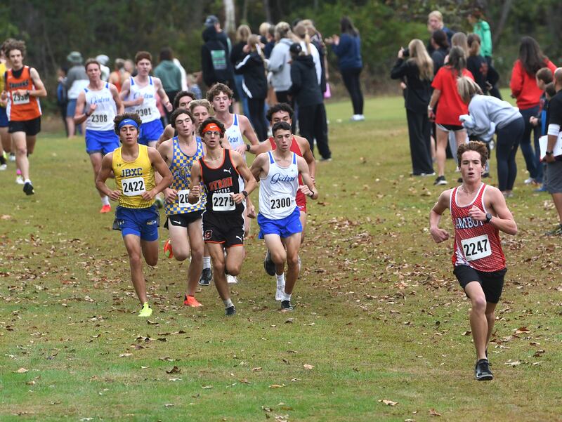 Amboy's Henry Nichols (right) leads a pack of runners as he chases the leader at the Amboy Columbus Day Cross Country Invitational held at Shady Oaks Country Club near Amboy on Monday, Oct. 13, 2025. He finished seventh.