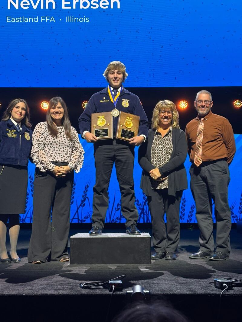 Nevin Erbsen (center) receives the American Star in Agricultural Placement award during the National FFA Convention & Expo. He is congratulated on stage by Caroline Groth (from left), National FFA eastern region vice president; Cindy Feltmeyer, Eastland FFA Chapter adviser; and his parents, Becky and Carl Erbsen.