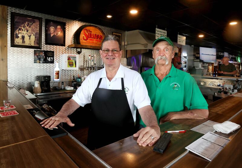 Earl (left) and Greg Sullivan, who own Sullivan's Tavern with brother Albert and sister-in-law Cindy, (not pictured) stand behind the bar Thursday, May 15, 2025, at the tavern in DeKalb. The bar is celebrating 80 years in business with an event Saturday, May 17, that will include food and live entertainment.