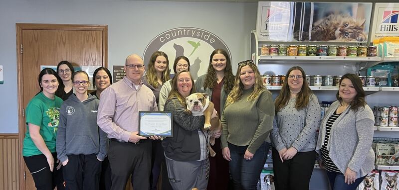 (From left, back row) Marissa Grimm, Devon Devalee, Chamber Ambassador; Danielle Ethington, Hollie Kolesar, Bridgit McFadin, Kaylee Maier, and Kenzie Erschen. (Front row) Ben Hiltabrand, Chamber Board President; Dr. Abby Eiten and Gladys; Dana Stillwell, Chamber Board Member; Beth Palm, Chamber Board Member; and Tara Bedei, Streator Mayor, pose for a photo after Country Side Animal Clinic was named Streator chamber's February Business of the Month.
