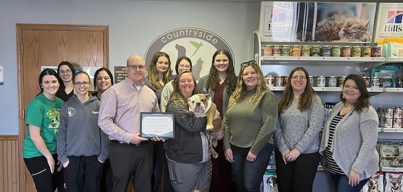 (From left, back row) Marissa Grimm, Devon Devalee, Chamber Ambassador; Danielle Ethington, Hollie Kolesar, Bridgit McFadin, Kaylee Maier, and Kenzie Erschen. (Front row) Ben Hiltabrand, Chamber Board President; Dr. Abby Eiten and Gladys; Dana Stillwell, Chamber Board Member; Beth Palm, Chamber Board Member; and Tara Bedei, Streator Mayor, pose for a photo after Country Side Animal Clinic was named Streator chamber's February Business of the Month.