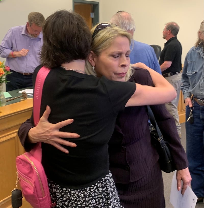 Juanita Gumble, right, hugs a supporter during a Hebron Village Board meeting on May 12, 2025, at which Gumble was rehired as police chief after being fired last year by a previous administration.