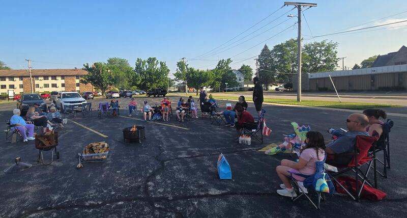 Members of the Plano Methodist Church gather round campfire.