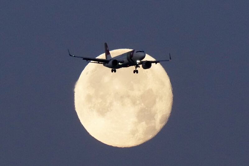 FILE - A TAP Air Portugal Airbus A320 is silhouetted against the setting moon while approaching for landing in Lisbon, Portugal, June 23, 2024. (AP Photo/Armando Franca, File)